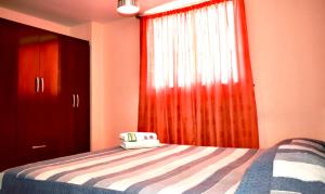 a bedroom with a bed with a red curtain at Alto Chinchorro Hostel in Arica