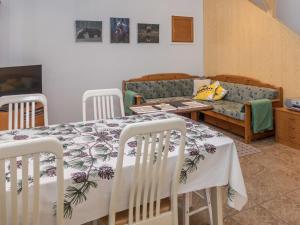 uma sala de estar com uma mesa e cadeiras e um sofá em Holiday Home Karhunvartijan linna b14 by Interhome em Ruka