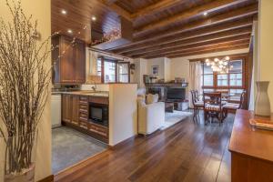 a kitchen and living room with wooden ceilings and a table at Jireta by Totiaran in Barruera