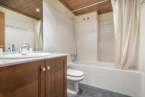 Un baño con lavabo, inodoro y bañera. en Jordana by Totiaran, en Baqueira Beret