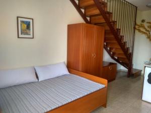 a bedroom with a bed and a staircase at Phyllis Maisonettes in Kallithea Halkidikis