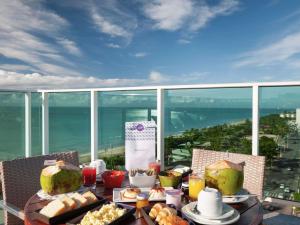 a table with food on it with a view of the ocean at Mercure Maceio Pajuçara in Maceió