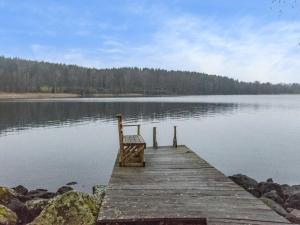 a dock with a bench sitting on top of a lake at Holiday Home Kärkimökki by Interhome in Hauho