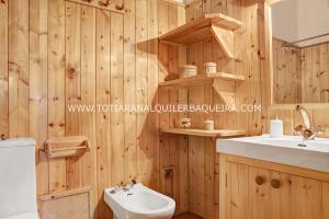 バケイラ・ベレットにあるApartamento Era Cascada By Totiaranのバスルーム(木製の壁、トイレ、洗面台付)