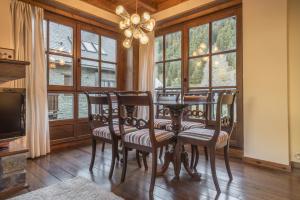 a dining room with a table and chairs and windows at Jireta by Totiaran in Barruera
