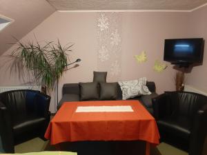 a living room with a couch and a table and chairs at Ferienzimmer Wenzel in Hasselfelde