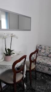sala de estar con mesa, sillas y sofá en MinihouseLarissa diVerona, en Verona