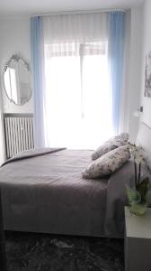 a bedroom with a bed with blue curtains and a window at MinihouseLarissa diVerona in Verona