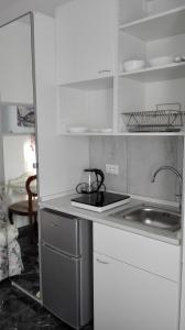a white kitchen with a sink and a stove at MinihouseLarissa diVerona in Verona