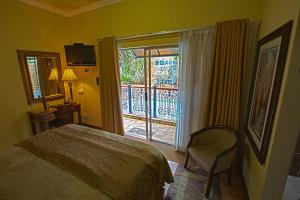 a bedroom with a bed and a sliding glass door at Le Cozmo Guesthouse in Johannesburg