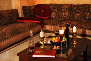 sala de estar con sofá y mesa con velas en Perimasali Cave Hotel - Cappadocia, en Ürgüp