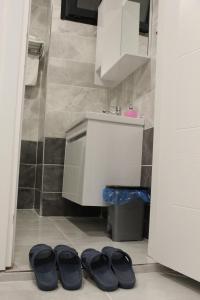 - une paire de chaussures noires dans une salle de bains avec lavabo dans l'établissement IVY SULTANAHMET, à Istanbul