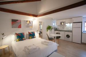 Cet appartement comprend une chambre avec un grand lit blanc et une cuisine. dans l'établissement Gran Central Suites, à Madrid