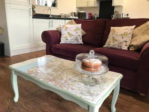 a coffee table with a cake on top of it at Riding Farm Cottages in Gateshead