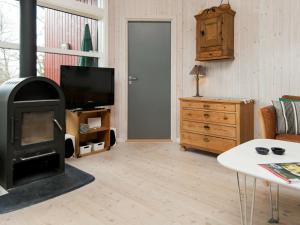 a living room with a fireplace and a television at 8 person holiday home in Glesborg in Glesborg