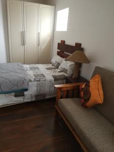 a bedroom with a bed and a couch and a lamp at Bona Lodge in Cape Town +16 photos