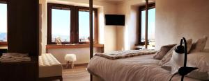 sypialnia z łóżkiem i oknami z widokiem w obiekcie Villa Ciardi Wellness Hotel & Ristorante w mieście Roana