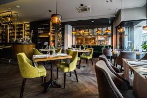 restauracja ze stołami i krzesłami oraz bar w obiekcie Hotel Perfect w Krakowie