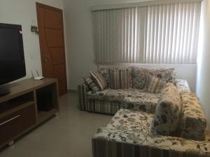 uma sala de estar com um sofá e uma televisão em APARTAMENTO ACONCHEGANTE em Uberlândia