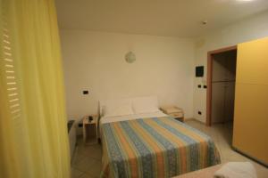 a small bedroom with a bed with a colorful blanket at Residence Beach Paradise in Rimini