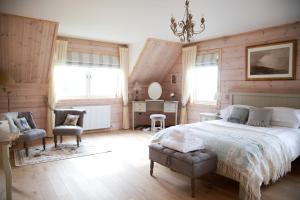 a bedroom with a bed and a chair and windows at Netherton Farm Lodge in Kemnay