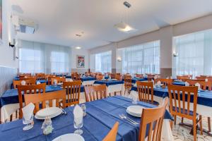 a dining room with blue tables and chairs at Hotel Bremen in Rimini