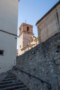 a building with a clock tower on top of a stone wall at Apartamentos Prades in Morella
