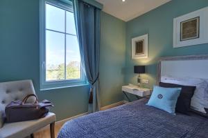 a blue bedroom with a bed and a window at Les Villas d'Arromanches, Teritoria in Arromanches-les-Bains +37 photos