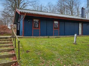 une maison bleue avec une clôture devant elle dans l'établissement 5 person holiday home in TJ RNARP, à Tjörnarp