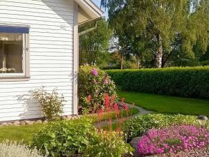 a garden of flowers next to a house at 8 person holiday home in LERUM in Lerum