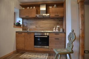 a kitchen with wooden cabinets and a sink and a chair at Maso Bolpis in Trento