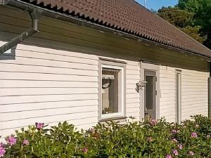 una casa blanca con una ventana y algunas flores en 8 person holiday home in LERUM, en Lerum