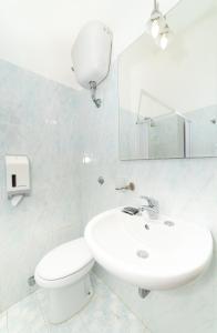 a bathroom with a sink and a toilet and a mirror at San Francesco Heritage Hotel in Alghero