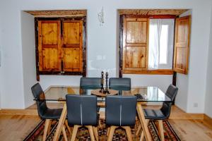 a dining room with a glass table and chairs at Casa Gil Vicente in Almada