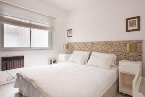 Un dormitorio blanco con una cama grande y una ventana en Hermoso apartamento en Recoleta para 2/3 personas. Espectacular ubicación ! en Buenos Aires