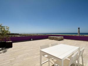 Biały stół i krzesła na patio z widokiem na ocean w obiekcie Luxe Penthouse Casa Atlantica Morro Jable Sea Views By PVL w mieście Morro del Jable