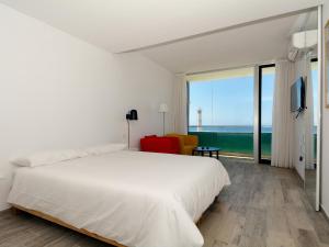 sypialnia z białym łóżkiem i dużym oknem w obiekcie Luxe Penthouse Casa Atlantica Morro Jable Sea Views By PVL w mieście Morro del Jable
