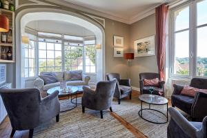ein Wohnzimmer mit Stühlen und einem Tisch in der Unterkunft Les Villas d'Arromanches, Teritoria in Arromanches-les-Bains