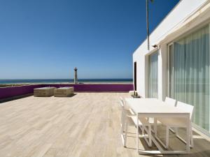 biały stół i krzesła na balkonie z widokiem na ocean w obiekcie Luxe Penthouse Casa Atlantica Morro Jable Sea Views By PVL w mieście Morro del Jable