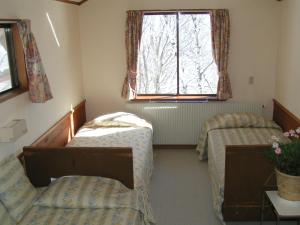 Habitación con 2 camas y ventana en Madarao Elm Pension en Iiyama