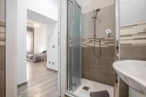 La salle de bains est pourvue d'une douche et d'un lavabo. dans l'établissement Scirocco Rooms, à Civitavecchia