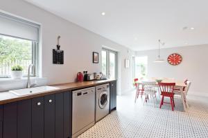 uma cozinha com uma máquina de lavar roupa e uma sala de jantar em Connells House Thatched Cottage em Duleek