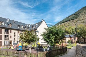 a town in the mountains with a fence and a playground at Montcorbison by Totiaran in Vielha