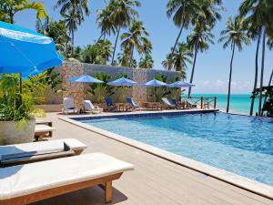 雅帕拉廷加的住宿－Vila de Taipa Exclusive Hotel，度假村的游泳池,配有椅子和遮阳伞
