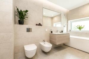 a bathroom with a toilet and a sink at Imanta Garden Townhouses in Riga