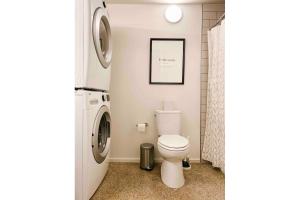 a bathroom with a toilet and a washer and dryer at Cozy Downtown Loft in Knoxville
