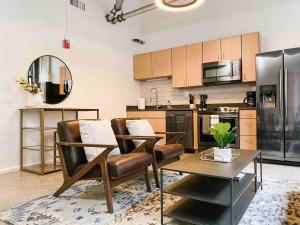 a kitchen with leather chairs and a table and a refrigerator at Cozy Downtown Loft in Knoxville