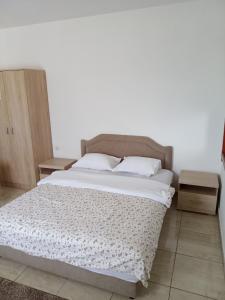 sypialnia z dużym łóżkiem z białą pościelą i poduszkami w obiekcie Apartments Šofranac w mieście Podgorica