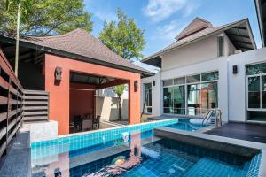 an exterior view of a house with a swimming pool at AnB pool villa (Red) with 2BR close to Jomtien beach in Na Jomtien