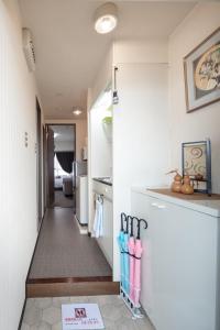 a hallway leading into a kitchen with a refrigerator at Cozy house K46, free wifi a rented electric bicycle in Kyoto